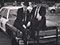 This is a photo of Dave Wiggins and Christopher Till sat on the bonnet of their 1974 Dodge Moncao. They are a Blues Brothers Tribute Act.